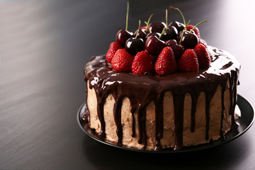 Delicious cake with cherry and strawberry on table