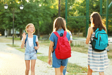 Teenagers with backpacks meeting in park