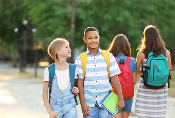 Teenagers with backpacks and notebooks on walking in the park