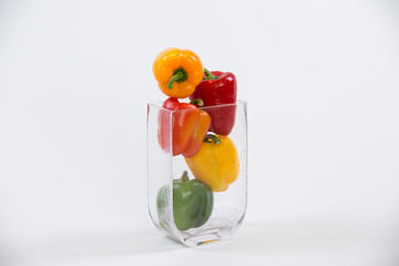 Mixed bell peppers in a glass vase full frame side