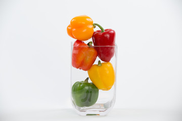 Mixed bell peppers in a glass vase full frame flat on