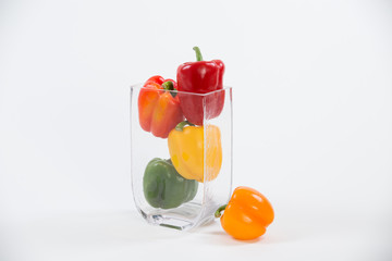 Mixed bell peppers in a glass vase full frame single on side