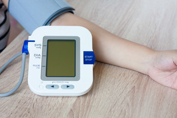 Woman using digital blood pressure monitor