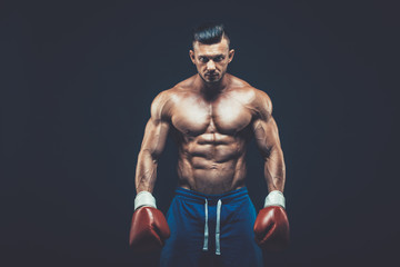 Fototapeta na wymiar Muscular boxer in studio shooting, on black background.