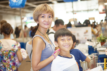 Obraz premium mother and son waiting for checkout in shopping mall