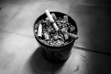 The ash of cigarettes on the ashtray. Dark tone low key.