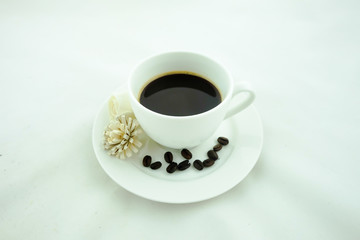 A cup of coffee and coffee beans. White background.