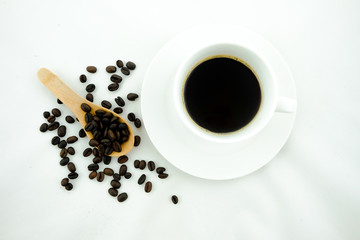 A cup of coffee and coffee beans. White background.