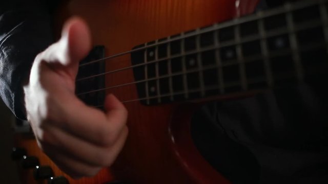 Bass guitar player close up playing virtuoso bass with fingers and slap