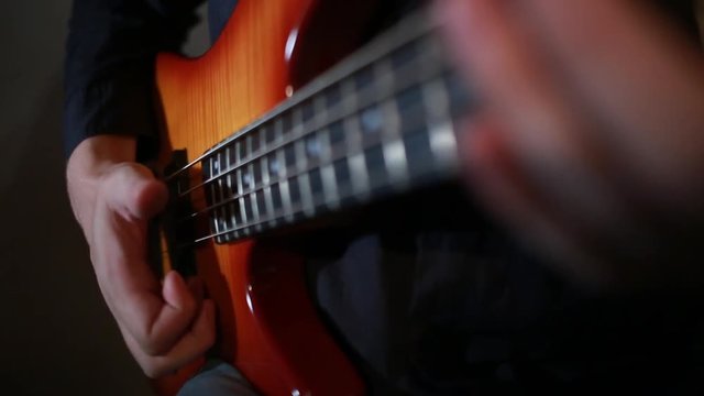 Bass guitar player close up playing virtuoso bass with fingers and slap