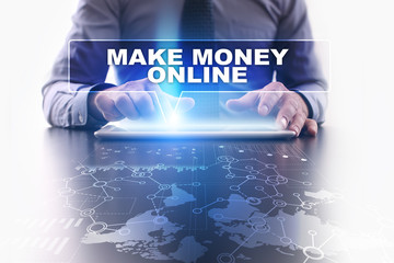 Fototapeta na wymiar Businessman is using tablet pc, pressing on virtual screen and selecting make money online.