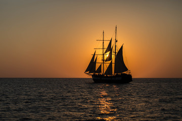 Fototapeta na wymiar Silhouette of a Ship on the Sea at Sunset in Santorini