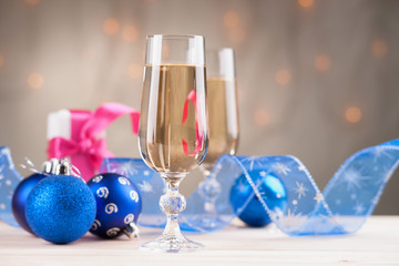 Glasses of champagne with gift box and christmas balls 