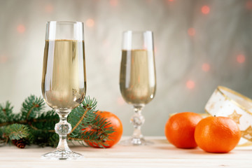 Fir tree branch, ribbon, mandarins and glasses of champagne 