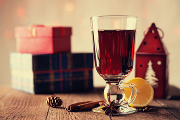 Hot mulled wine with spices, gift boxes and house shaped candlestick 