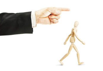 Man going in shown direction. Concept of full obedience. Abstract image with a wooden puppet