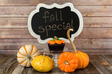 Fall pumpkin muffin with chalkboard sign and decorative gourds
