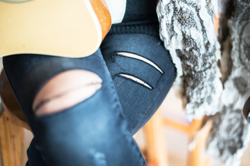 Stylish women sitting in torn jeans. Fashion, lifestyle, beauty, clothing.