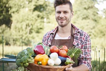 Obraz premium Man with basket full of vegetables