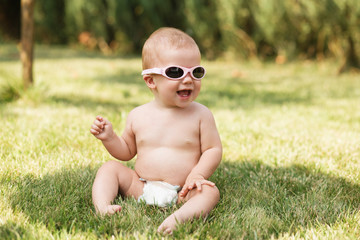 beautiful baby sitting on green grass outdoors © nata_zhekova