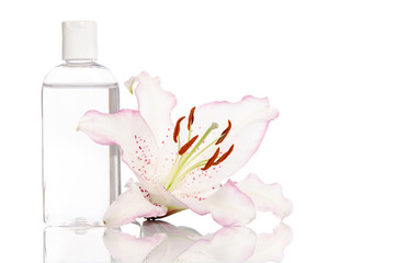 tonic for skin care with lily flower on a white background