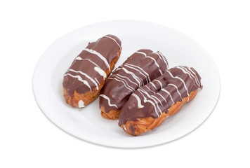 Eclairs with whipped cream and chocolate icing on white dish