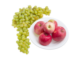 Several red apples on dish and cluster of white grapes