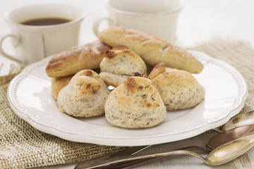almond cookies on white plate and coffee on woden background