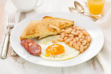 fried egg with beans, smoked sausage and toasts