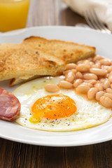 fried egg with beans, smoked sausage and toasts