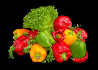 Several green, yellow and red bell peppers among the greens