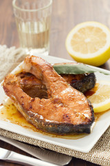 fried salmon with lemon on white dish