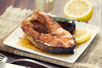 fried salmon with lemon on white dish