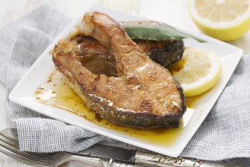 fried salmon on white plate on wooden background