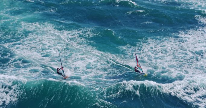 Aerial view of windsurfers gliding across blue ocean, extreme sport