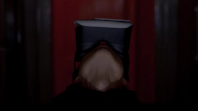 Criminal programmer in hood using VR glasses in dark room close up
