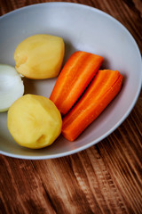Poseshenie vegetables to prepare vegetable soup with spices on a light plate .