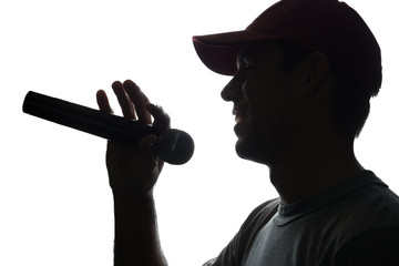 Young man in cap singing into a microphone