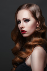 Fashion beauty portrait of gorgeous girl with curls and red lipstick in the style of Hollywood on a black background