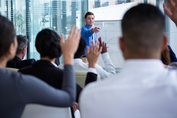 Colleagues raising their hands during meeting