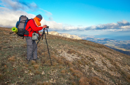 Photographer takes pictures on top of the mountain in autumn. 