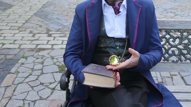 man in retro suit at bench looking time on his pocketwatch