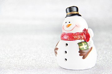 Merry Christmas or Happy New Year concept : Cute snowman doll on silver glitter paper background