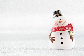 Merry Christmas or Happy New Year concept : Cute snowman doll on silver glitter paper background