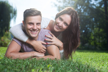 couple lying at grass in park in summer