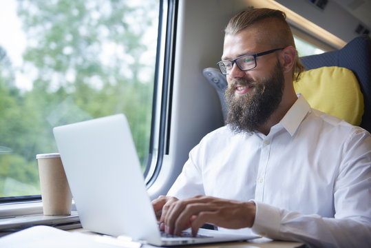 Businessman with beard working during the journey