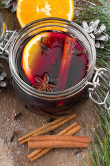 Christmas drink with orange fruit, anise, cinnamon and cloves on wooden table