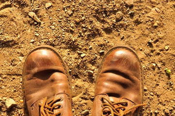 Dirty old shoes on dust background