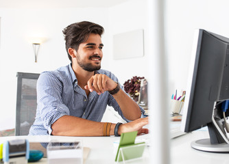 Portrait of male programmer using computer in a bright office.