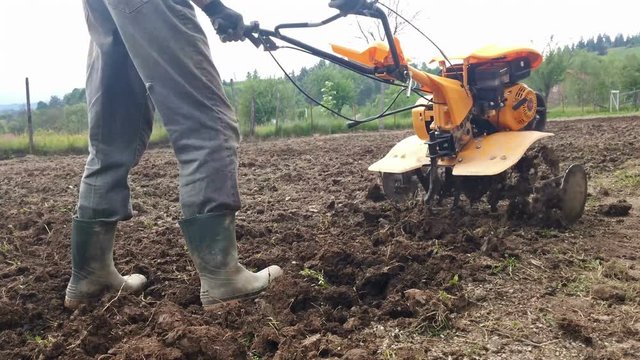Man plowing field with cultivator